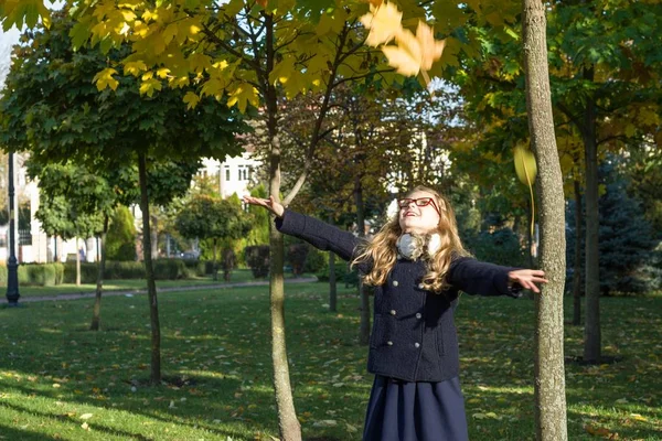 Fondo soleado de otoño, niña está jugando con hojas de arce amarillo, espacio de copia — Foto de Stock