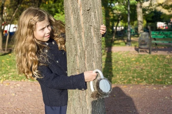 Herfst zonnige achtergrond, klein meisje in de buurt van een boom, kopieer ruimte. — Stockfoto