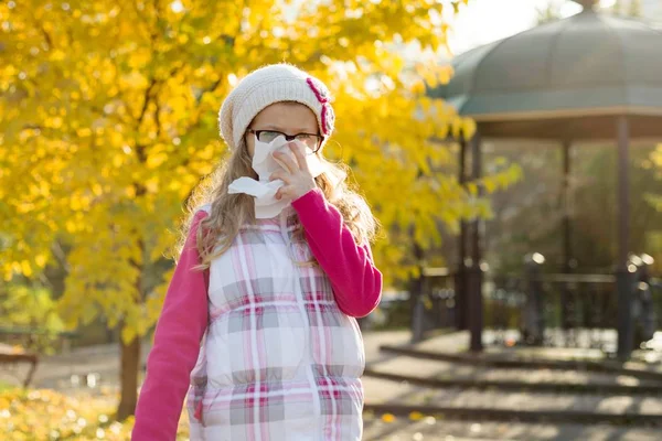 Frozen sick girl with a handkerchief, background yellow autumn trees — Stock Photo, Image