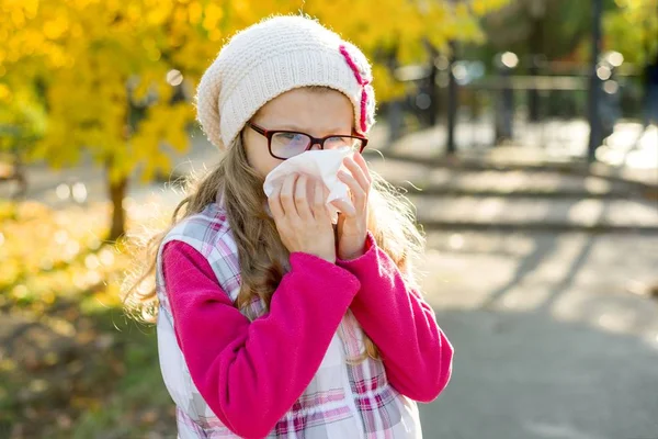 Menina criança com rinite fria no fundo do outono, estação da gripe, nariz escorrendo alergia — Fotografia de Stock
