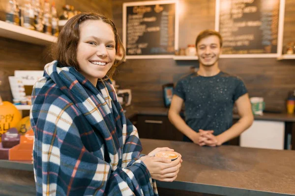 Outono de inverno retrato de jovem adolescente com uma xícara de café e coberto com cobertor xadrez de lã no café — Fotografia de Stock