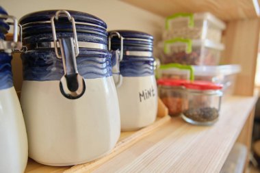 Kilerde yiyecek ve mutfak gereçleri ile ahşap raflar