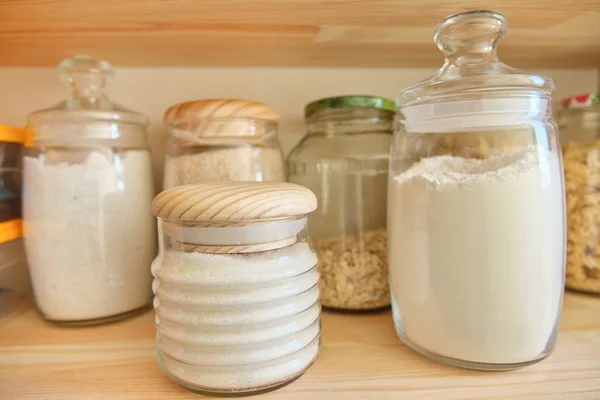 Storage cabinet in kitchen with wooden shelves with food