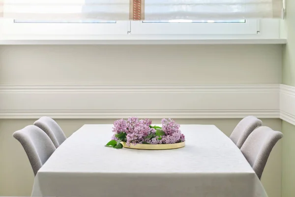 Salon z jadalnią z 4 krzesłami w pobliżu okna, bukiet kwiatów liliowy na stole — Zdjęcie stockowe