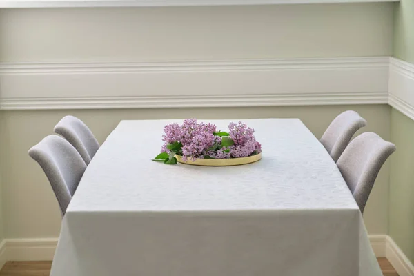 Salon z jadalnią z 4 krzesłami w pobliżu okna, bukiet kwiatów liliowy na stole — Zdjęcie stockowe