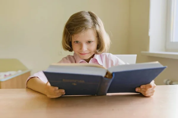 Μικρό κορίτσι φοιτητής που σπουδάζουν στο γραφείο με το βιβλίο. — Φωτογραφία Αρχείου