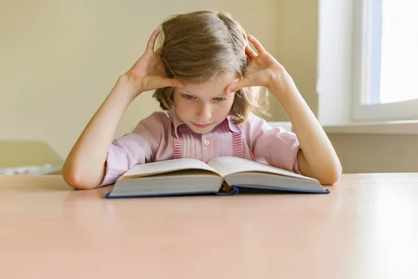 Niña estudiante estudiando en el escritorio con libro . — Foto de Stock