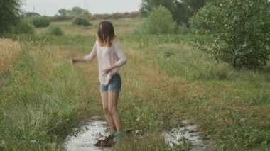 Çok çamurlu su birikintisi atlama güzel gülümseyen genç kız