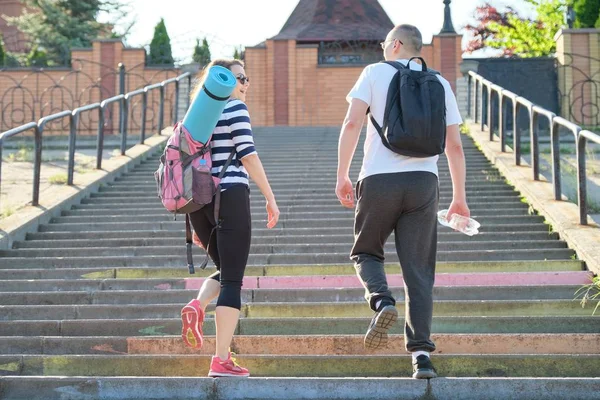 Middle-aged man and woman in sportswear talking walking. — Stock Photo, Image