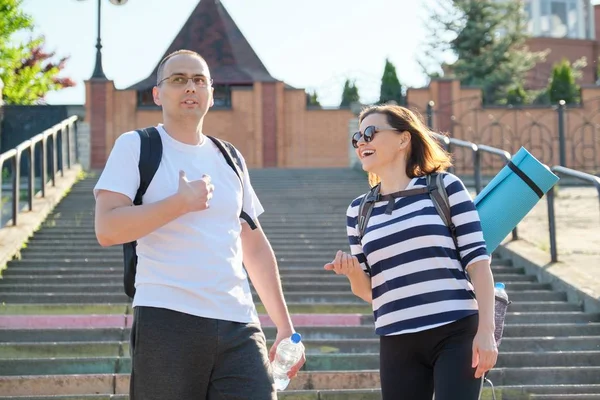 Medelålders man och kvinna i sportkläder pratar promenader. — Stockfoto