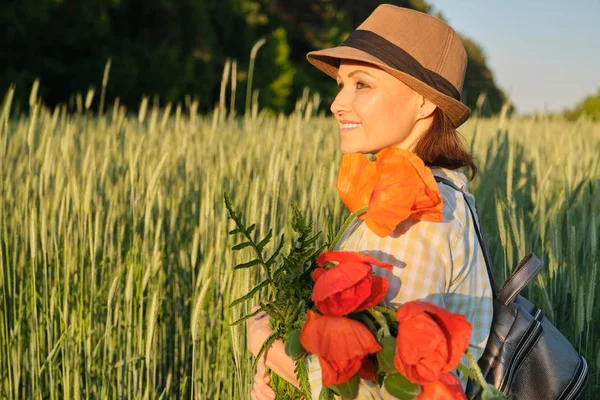 Ritratto esterno di donna matura felice con mazzi di fiori di papaveri rossi — Foto Stock