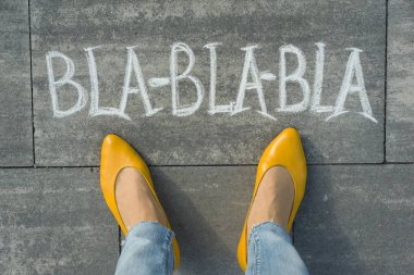 Kadın ayakları ile metin bla-bla-bla gri kaldırımda yazılı