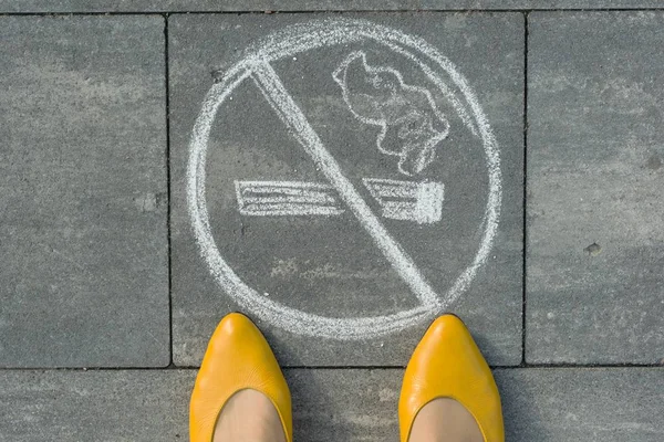 Pieds féminins avec tableau non fumeur peint sur le trottoir gris — Photo
