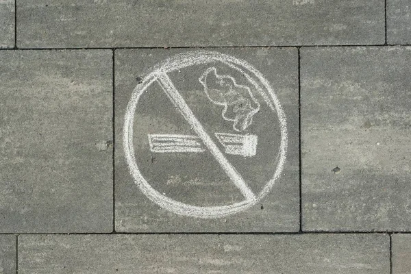 Sign no smoking painted on the grey sidewalk