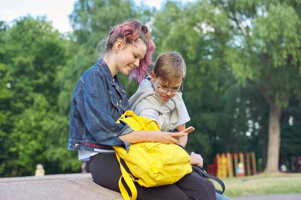 Зовнішній портрет двох розмовних підлітків зі смартфоном — стокове фото