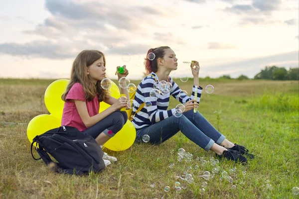 Dos chicas descansando en la naturaleza, niños con burbujas de jabón —  Fotos de Stock