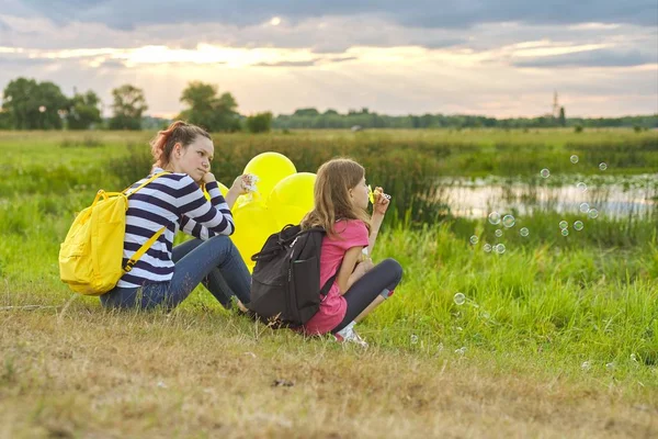 Dos chicas descansando en la naturaleza, niños con burbujas de jabón — Foto de Stock