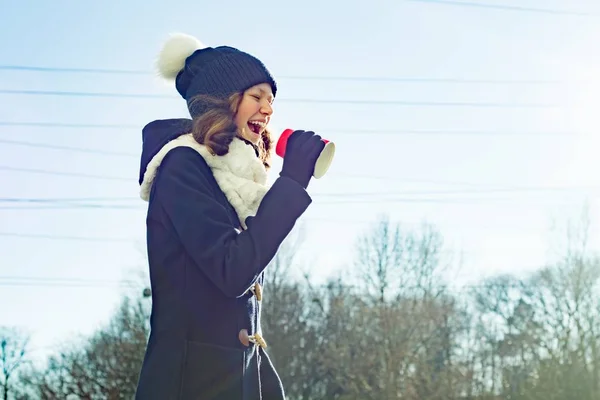 Χειμερινό υπαίθριο πορτρέτο του νεαρού κοριτσιού ουρλιάζοντας σε ένα μεγάφωνο χαρτί Κύπελλο, αντίγραφο χώρου — Φωτογραφία Αρχείου