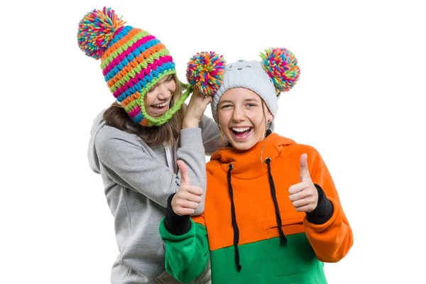 Χειμωνιάτικο πορτραίτο δύο χαρούμενοι χαμογελαστοί όμορφα κορίτσια σε πλεκτά καπέλα που διασκεδάζουν, απομονωμένα σε λευκό φόντο, άνθρωποι, νεολαία και έννοια της φιλίας — Φωτογραφία Αρχείου