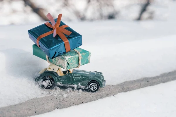Outdoor Toy Vintage retro auto met cadeaus voor Kerstmis en Nieuwjaar, auto op een besneeuwde weg. Zonnige Frosty winterdag, veel sneeuw — Stockfoto
