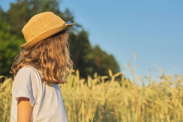 Lány gyerek szőke kalapban a búza területén, nyári naplemente — Stock Fotó