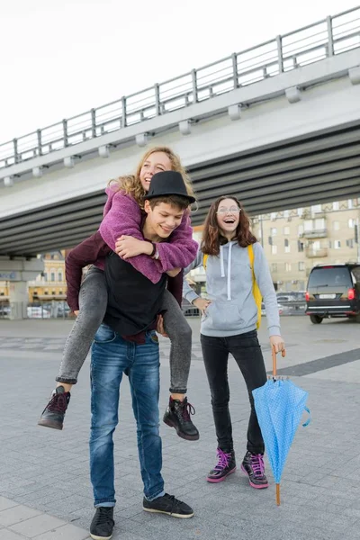 Adolescentes chico y dos niñas hablando y divertirse al aire libre — Foto de Stock