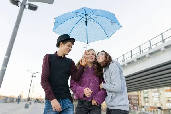 Tieners jongen en twee meisjes praten en plezier outdoor — Stockfoto