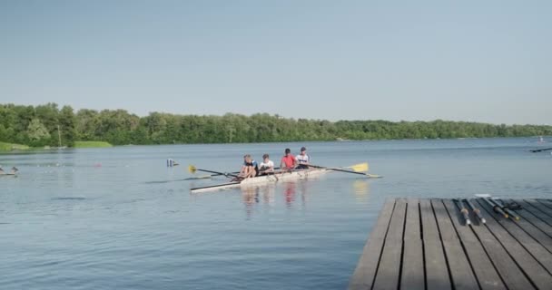 Kiev UA, 31-07-2019. Sport team van tiener jongens geleid door coach in kajak boot op het water — Stockvideo