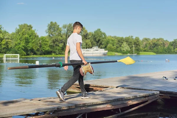 Adolescente chico cabalgando con paleta para deporte kayak barco — Foto de Stock