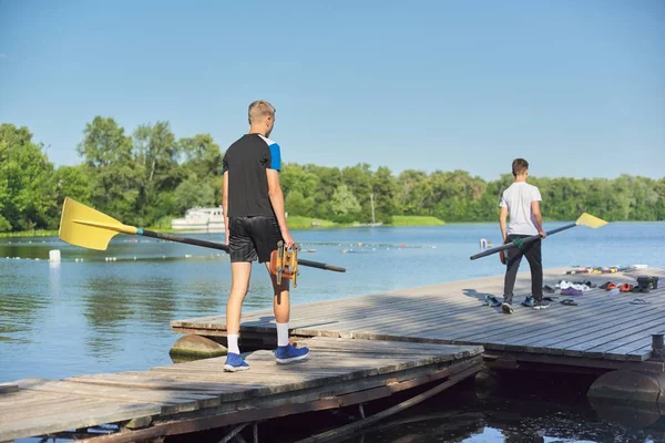 Kluci Teenageři chodí s pádlem pro sportovní kajakové lodě — Stock fotografie