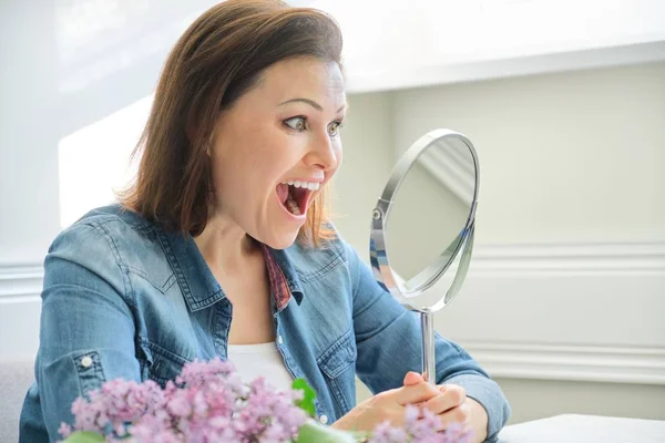 Rijpe vrouw kijkt in de spiegel en schreeuwend — Stockfoto