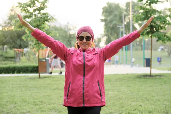 Portret van sportieve volwassen positieve vrouw met handen omhoog — Stockfoto