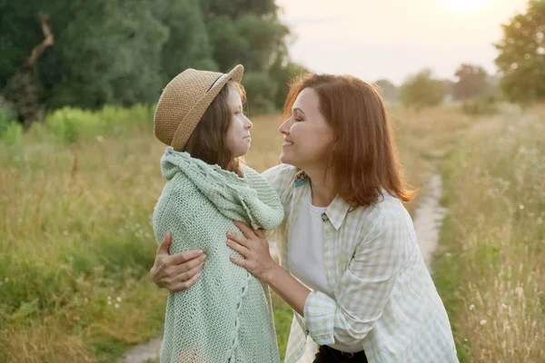 Anne ve kızı kucaklayan konuşuyor, yaz doğa