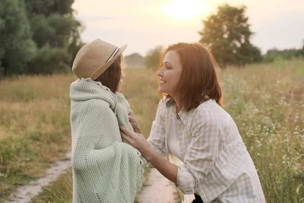 Güzel anne küçük kızına sarılıyor, konuşuyor, gülümsüyor