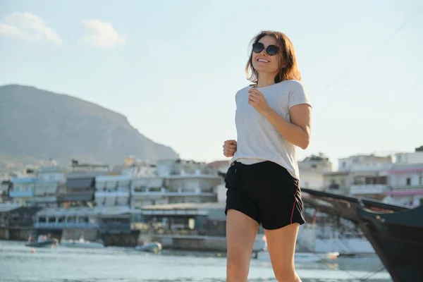 Sportieve volwassen vrouw joggen lopend aan zee promenade — Stockfoto