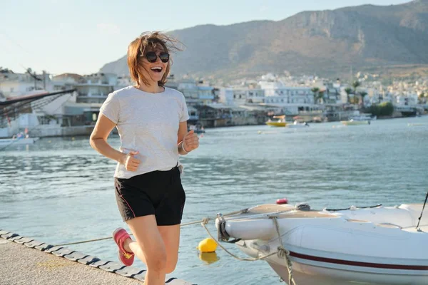 Lachende rijpe vrouw Running joggen op promenade — Stockfoto