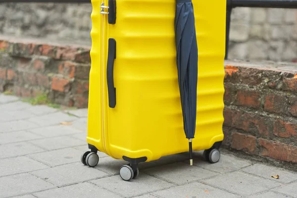 Conceito de turismo de viagens, mala de plástico amarelo, guarda-chuva — Fotografia de Stock