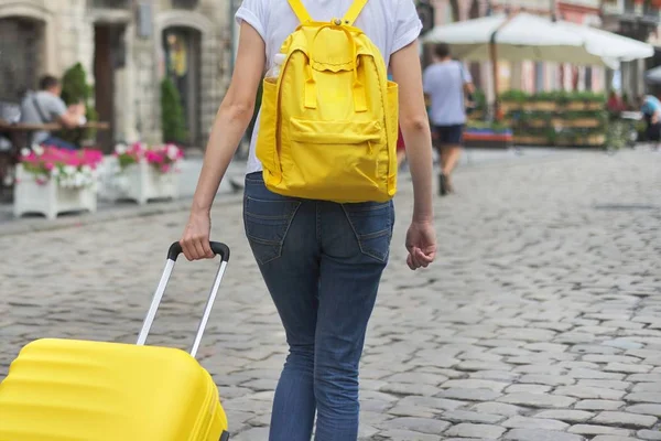 Menina andando com mochila e mala na cidade, vista traseira — Fotografia de Stock