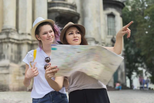 Women tourists mother and daughter teenager with map