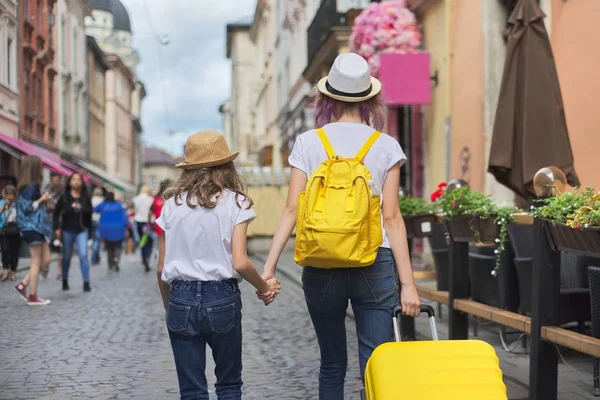 スーツケースを持って街を歩く2人の女の子、バックビュー — ストック写真
