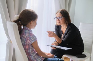 Sosyal hizmetler görevlisi bir kızla konuşuyor. Çocuk psikolojisi, akıl sağlığı