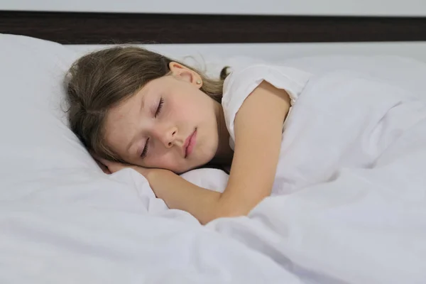 Спящая девочка на подушке, белая кровать, лицо крупным планом — стоковое фото