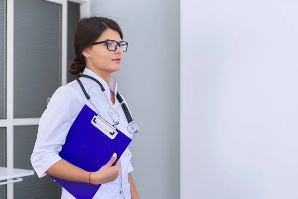 Retrato de jovem médica com prancheta de estetoscópio no hospital — Fotografia de Stock