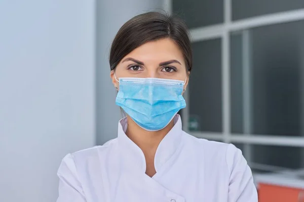 Retrato de una joven enfermera doctora en mascarilla médica protectora — Foto de Stock