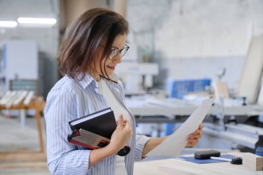 Marangozlukta çalışan bir kadın, endüstriyel portre. Ahşap atölyesinde bir kadın.
