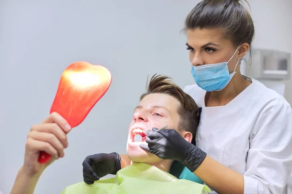 Lekarz dentysta leczy zęby nastolatkowi — Zdjęcie stockowe