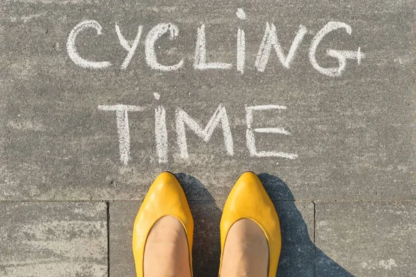 Czas jazdy na rowerze, tekst na szarym chodniku z kobiecymi nogami, widok z góry — Zdjęcie stockowe