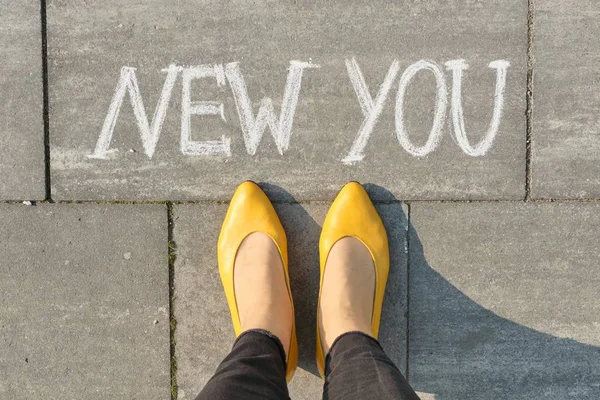 Texto novo que você escreveu na calçada cinza com as pernas das mulheres, vista superior — Fotografia de Stock