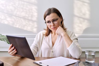 Kadın psikolog, psikiyatrist dijital tabletin web kamerasına bakıyor.