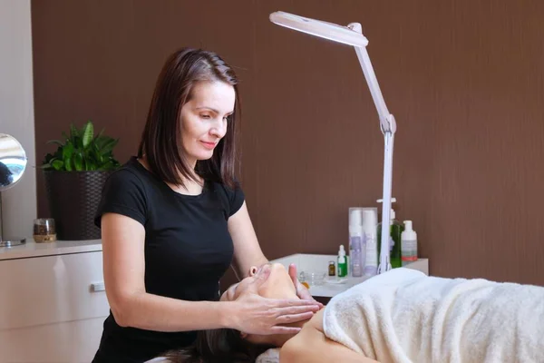 Mulher de meia-idade em escritório cosmetologista, recebendo tratamento de massagem anti-envelhecimento — Fotografia de Stock
